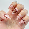 Hand with pink and gold nail design on a white background