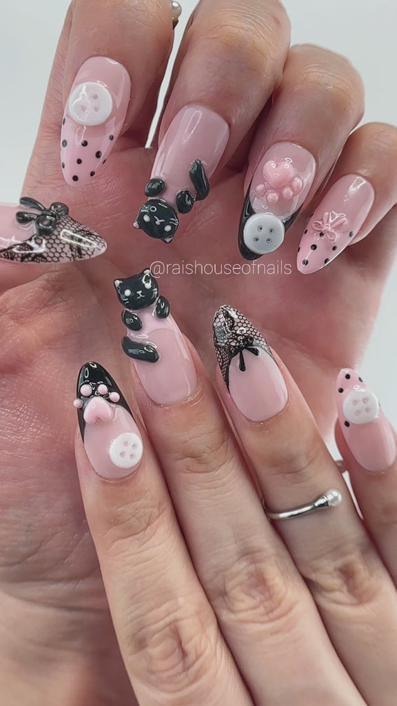 Video showing Rai's House of Nails 3D black cat press on nails in motion, with sculpted paw prints, bows, buttons, and lace details catching the light.