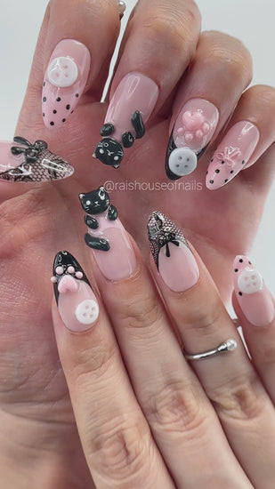 Video showing Rai's House of Nails 3D black cat press on nails in motion, with sculpted paw prints, bows, buttons, and lace details catching the light.