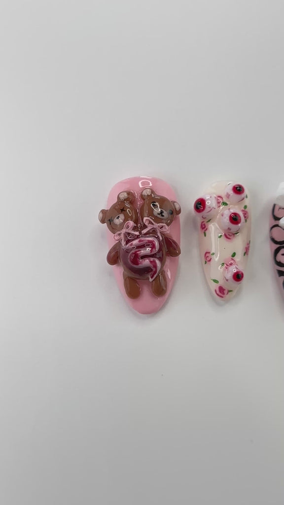 Video showing Rai's House of Nails horror teddy bear press on nails in motion, with the 3D gore texture, eyeballs, and bows catching the light.