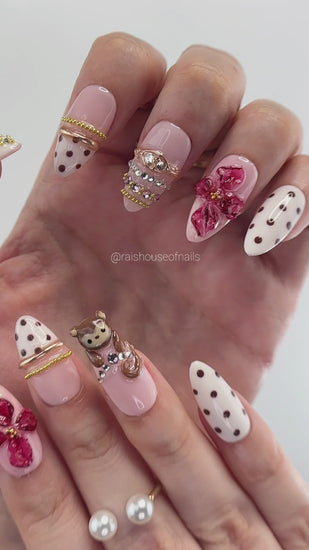 Video showing Rai's House of Nails 3D monkey and berry flower press on nails in motion, with glossy flowers, polka dots, and gold details catching the light.