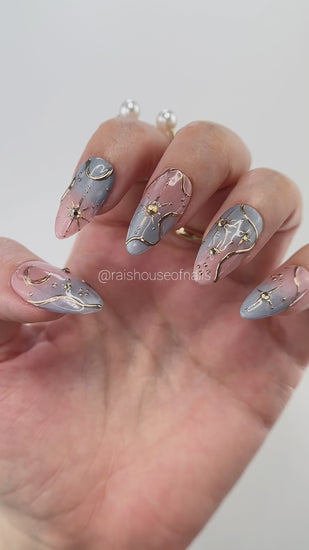 Video showing Rai's House of Nails celestial star press on nails in motion, with the gold chrome linework and cat eye shimmer shifting in the light.