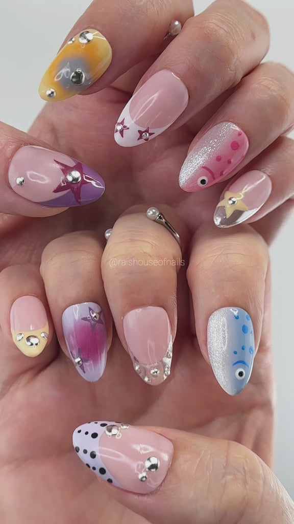 Video showing Rai's House of Nails fish and star press on nails in motion, with cat eye shimmer, aura effects, and silver beads catching the light.