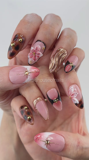 Video showing Rai's House of Nails tortoiseshell lily press on nails in motion, with the chrome swirl, gold stars, and floral details catching the light.