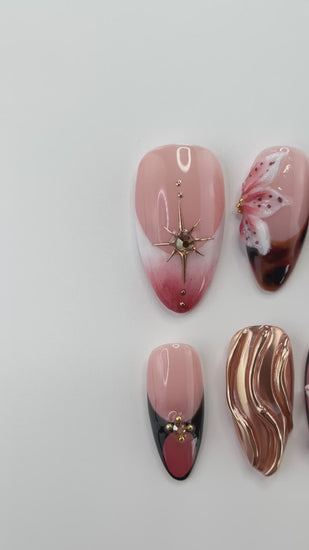Video showing Rai's House of Nails tortoiseshell lily press on nails in motion, with the chrome swirl, gold stars, and floral details catching the light.