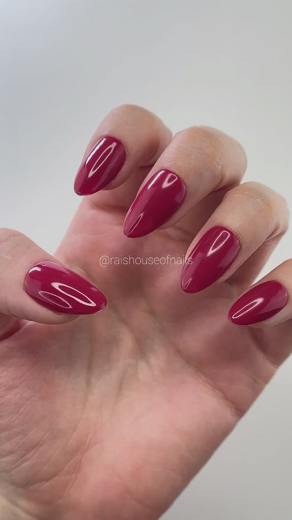 Video of Dark red solid color press on nails from the basic solids collection shown on hand, almond short, by Rai's House of Nails.